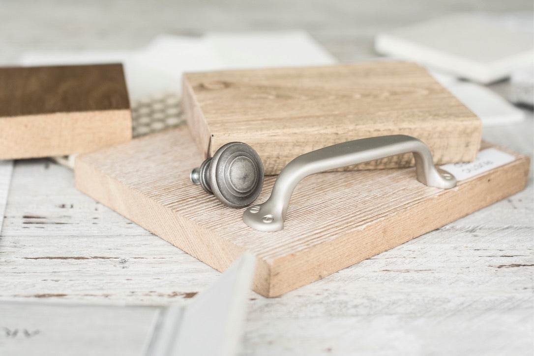 Wooden cutting board with metal handles on a light wooden surface