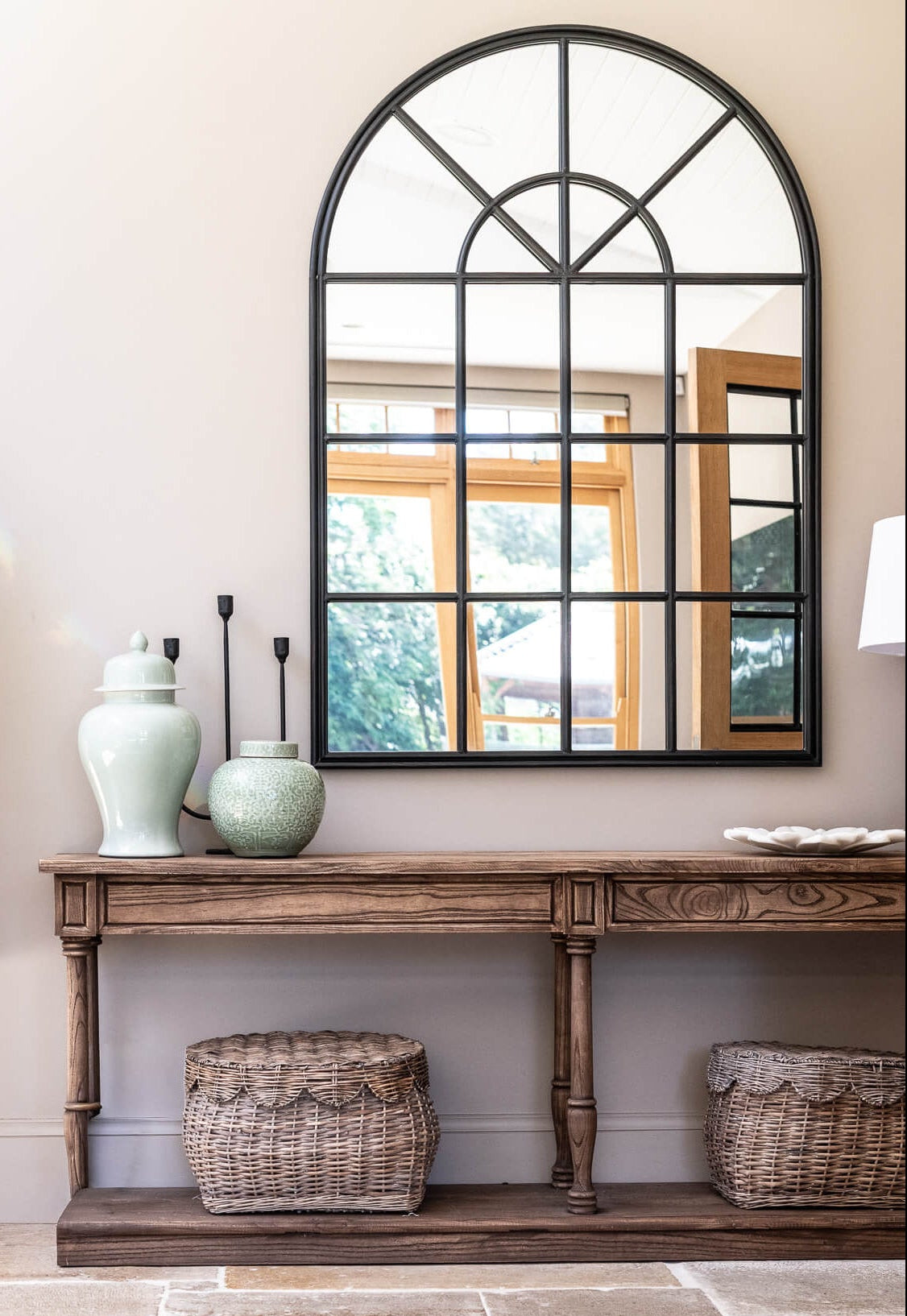 Entryway with wooden console table, decorative vases, and a large mirror.