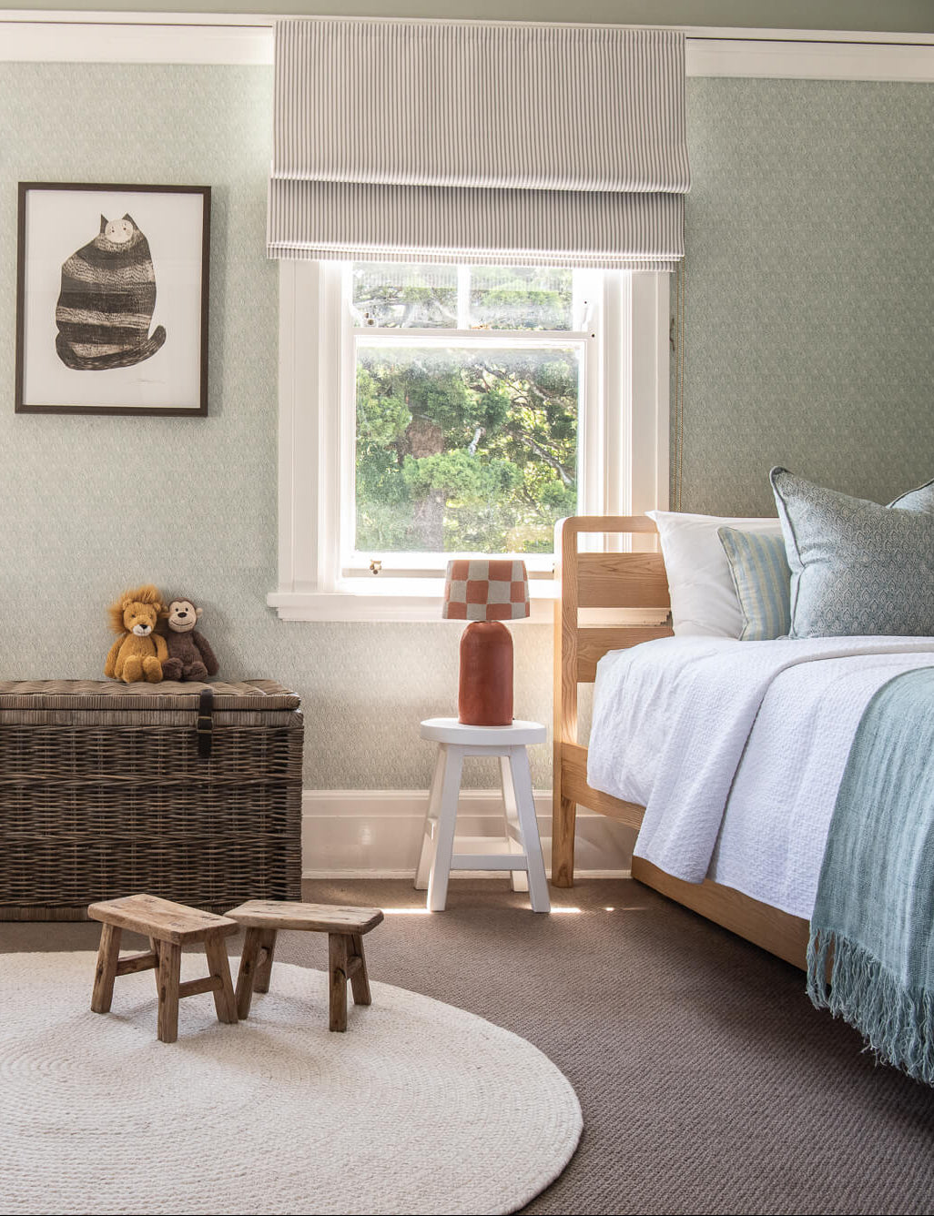 Children's bedroom with two beds, a rug, and toys.