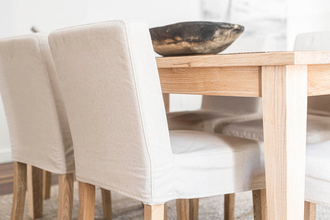 Dining table with beige chairs and a bowl on a white background