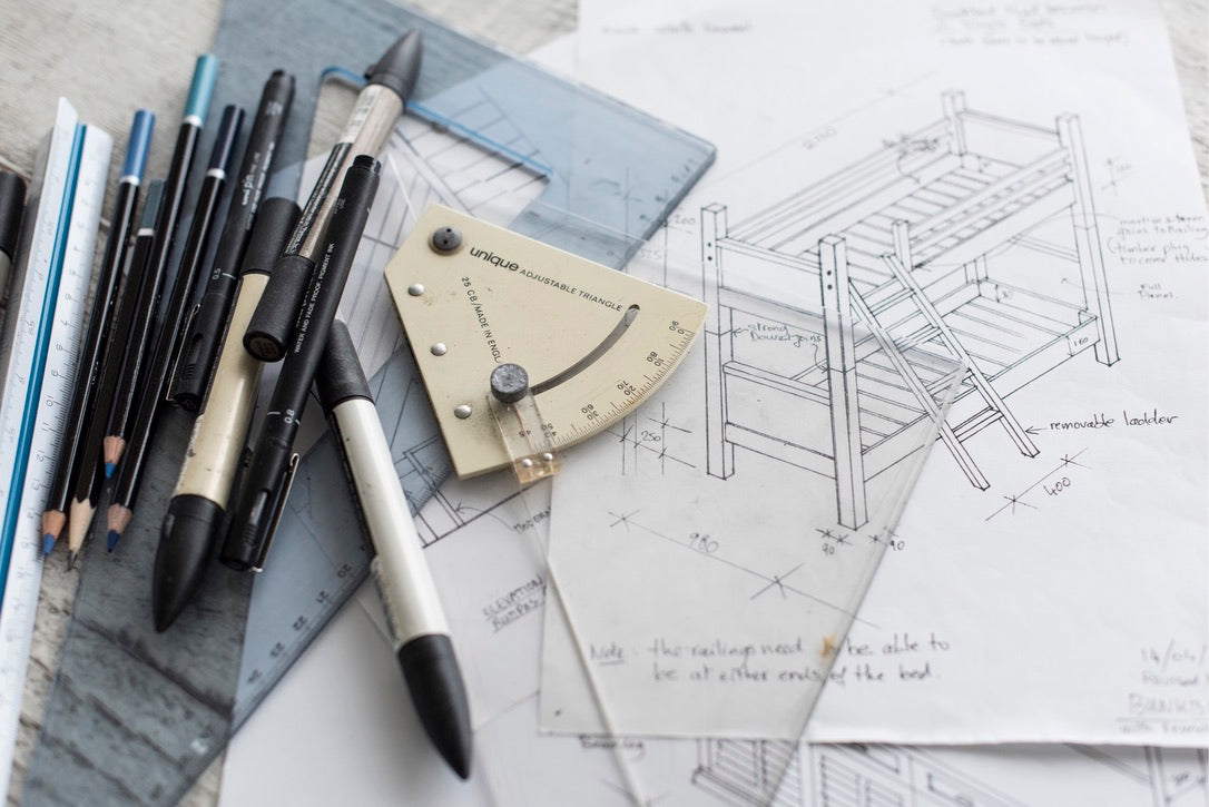 Drafting tools and architectural drawings of a bunk bed on a table