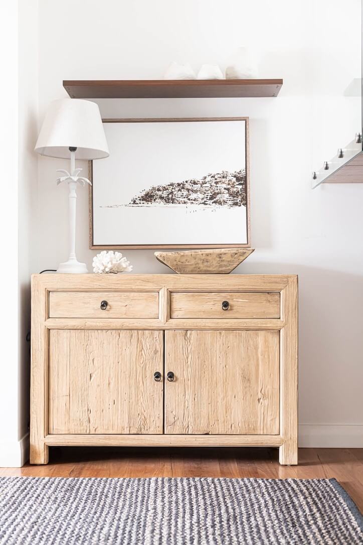 Light wooden elm sideboard with two doors and two drawers in a room setting.