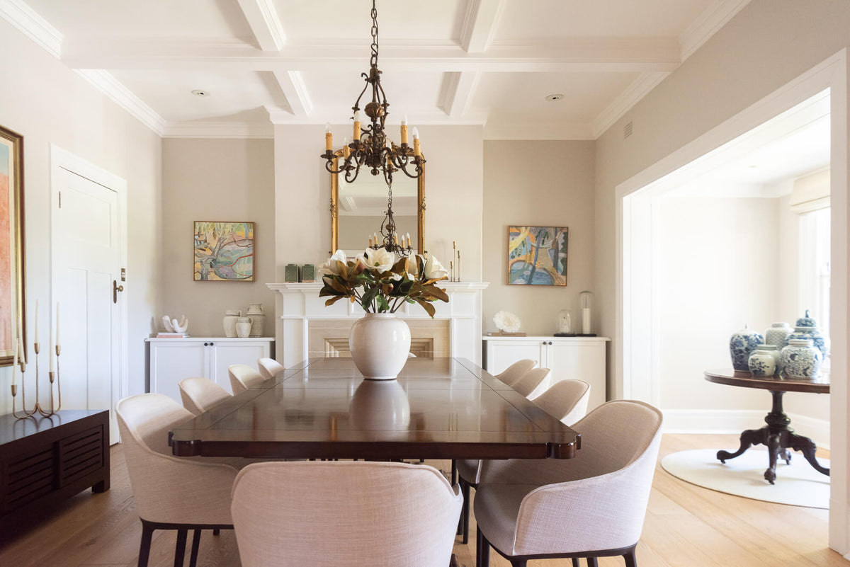 Dining room with a wooden table and chairs, a chandelier, and decorative items.