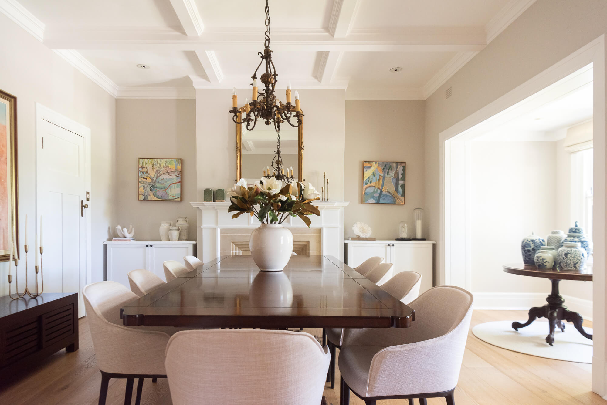 Dining room with a wooden table and chairs, a chandelier, and decorative items.