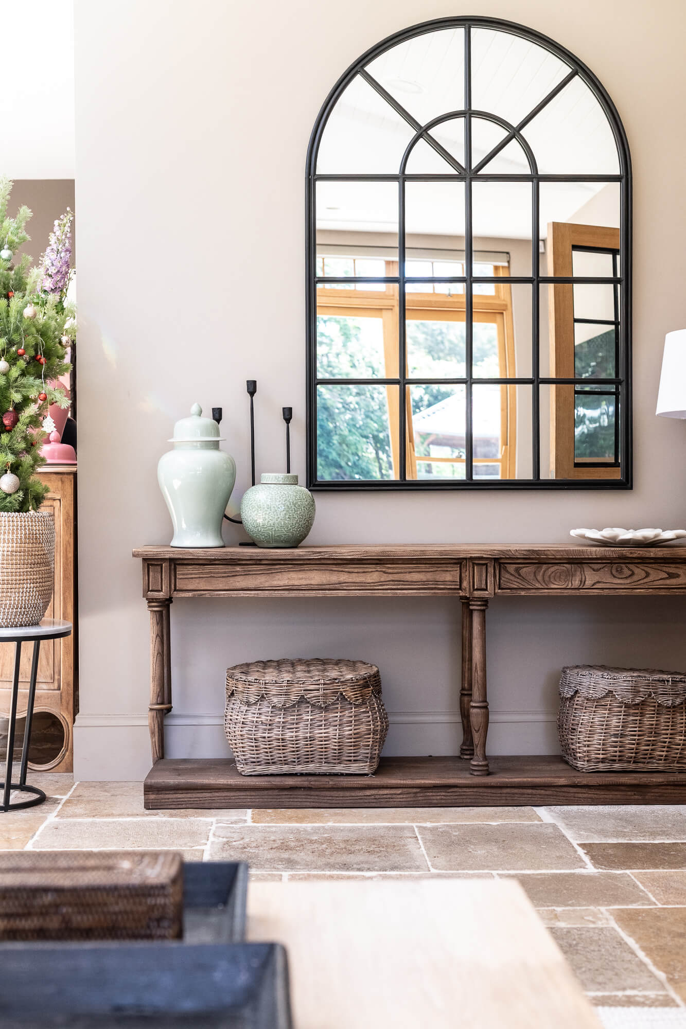 Entryway with wooden console table, decorative vases, and a large mirror.